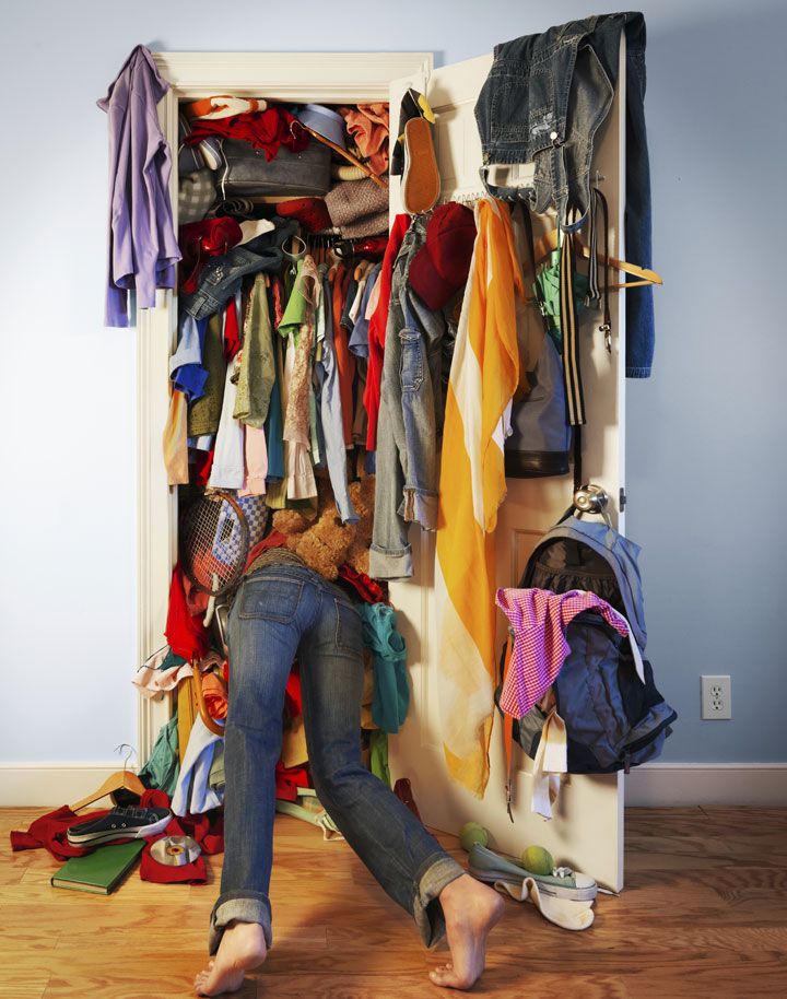 a woman standing in front of a closet filled with clothes