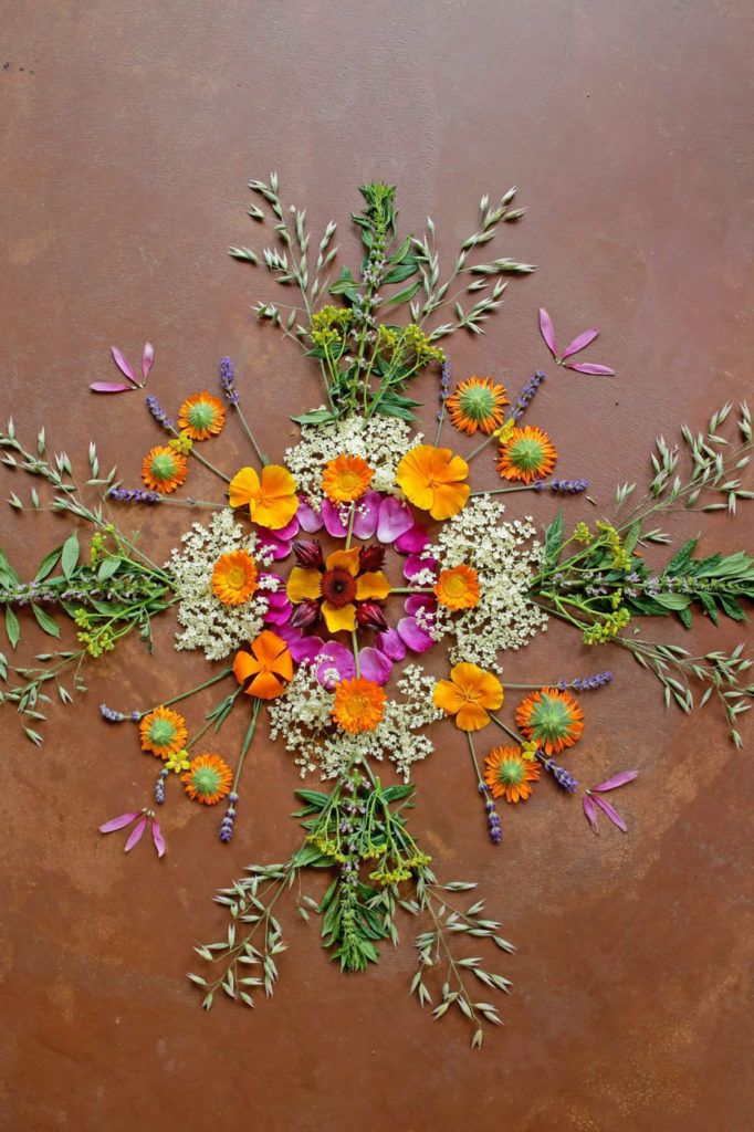 an arrangement of flowers arranged in the shape of a snowflake on a brown surface