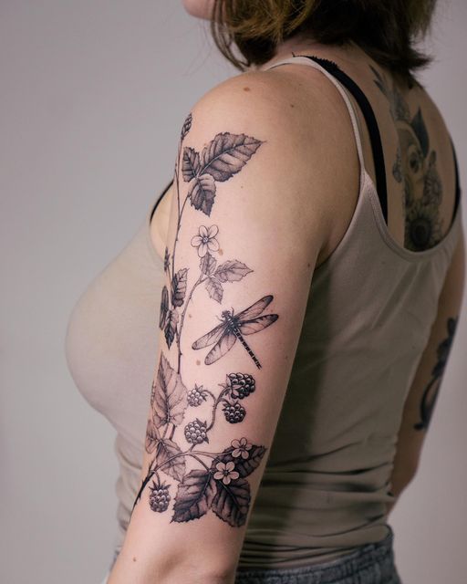 a woman with a dragonfly tattoo on her left arm and right arm behind her back