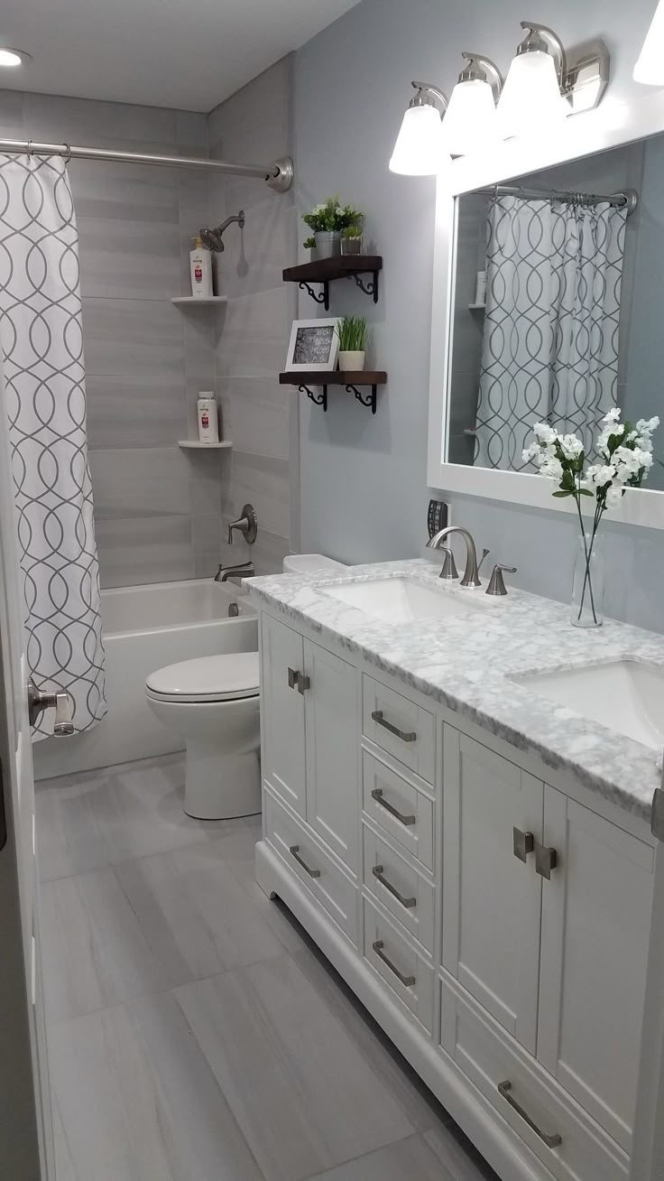 a white bathroom with two sinks, toilet and bathtub next to a shower curtain