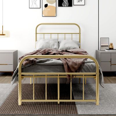 a bedroom with white walls and gold metal bed frame