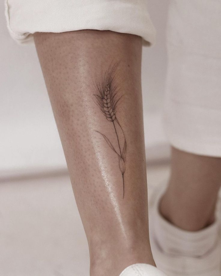 a woman's leg with a tattoo on it that has a plant growing out of it