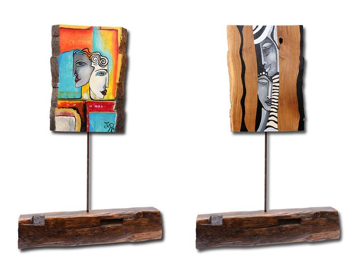 two pieces of wood with paintings on them sitting on top of each other in front of a white background