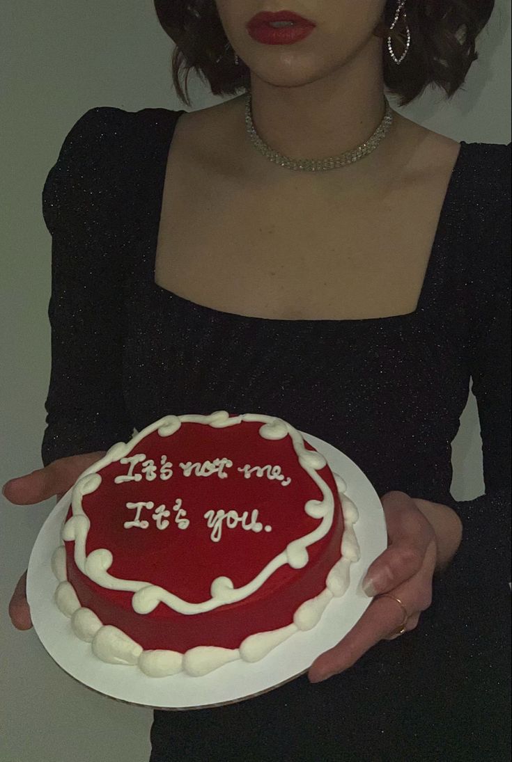 a woman holding a cake with the words it's not me, it's you