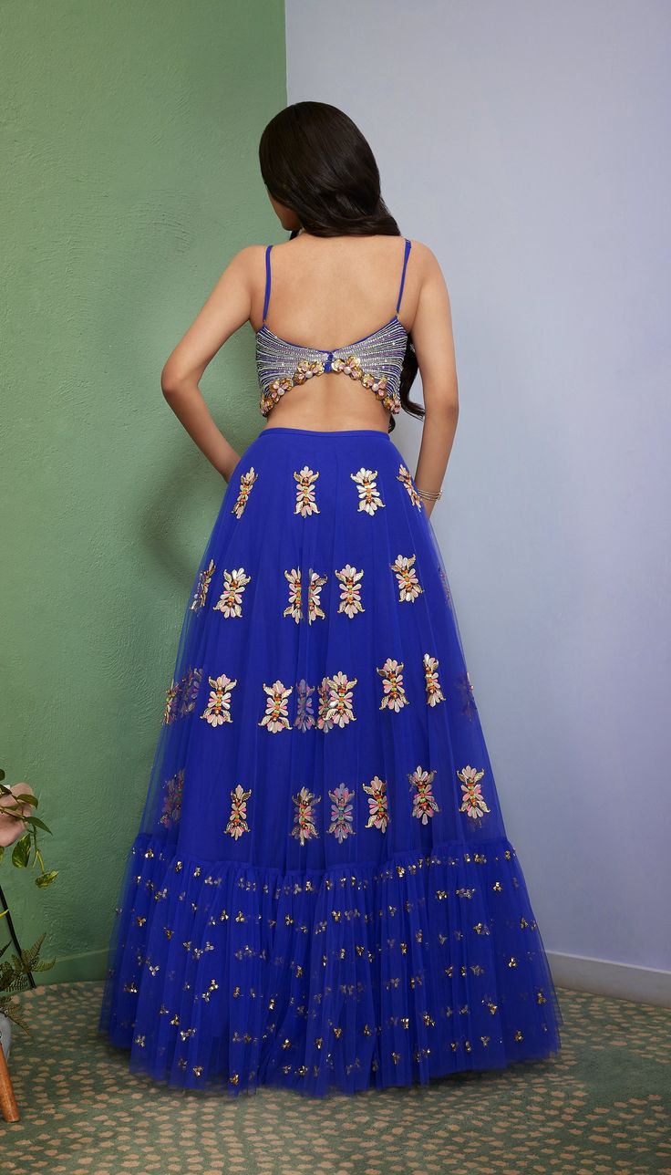 Introducing Artworq, a stunning iris blue lehenga designed to make you feel like royalty on your special day. Exquisitly crafted from a soft tulle base and embellished with shimmering glass crystals and intricate glass-cut beaded embroidery. The matching blouse features a stylish and modern cut, the piece comes with a matching dupatta, adorned with glass crystals and glass-cut beaded embroidery. From Papa Don’t Preach’s Capsule collection. DELIVERY TIMEPlease allow 8-12 weeks for your outfit to