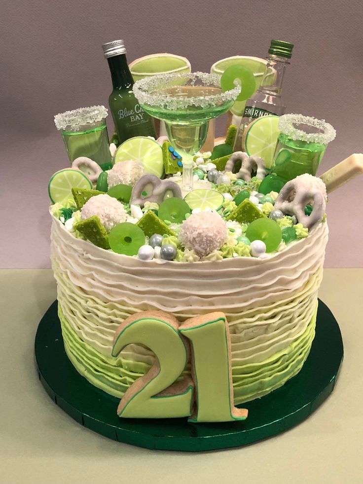 a birthday cake decorated with green and white candies, confetti and limes