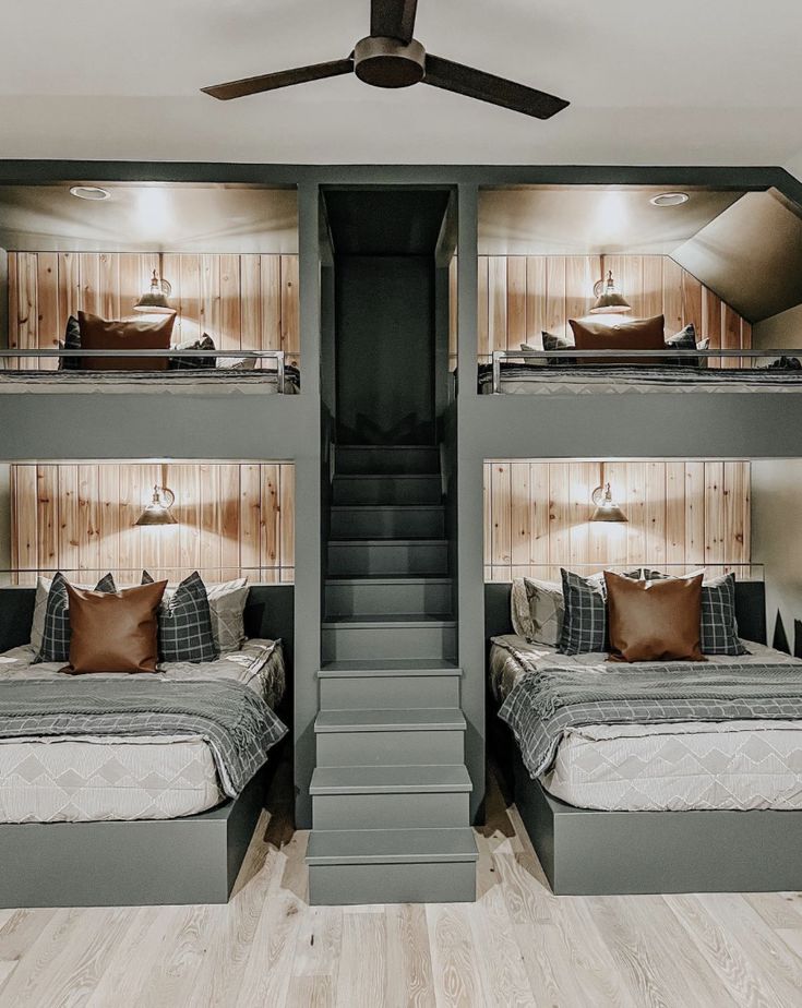 a bedroom with bunk beds and stairs leading to the upper level bed in this room