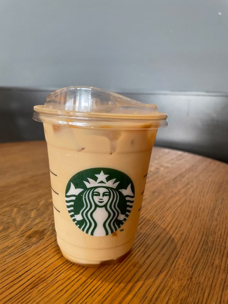 a starbucks drink sitting on top of a wooden table