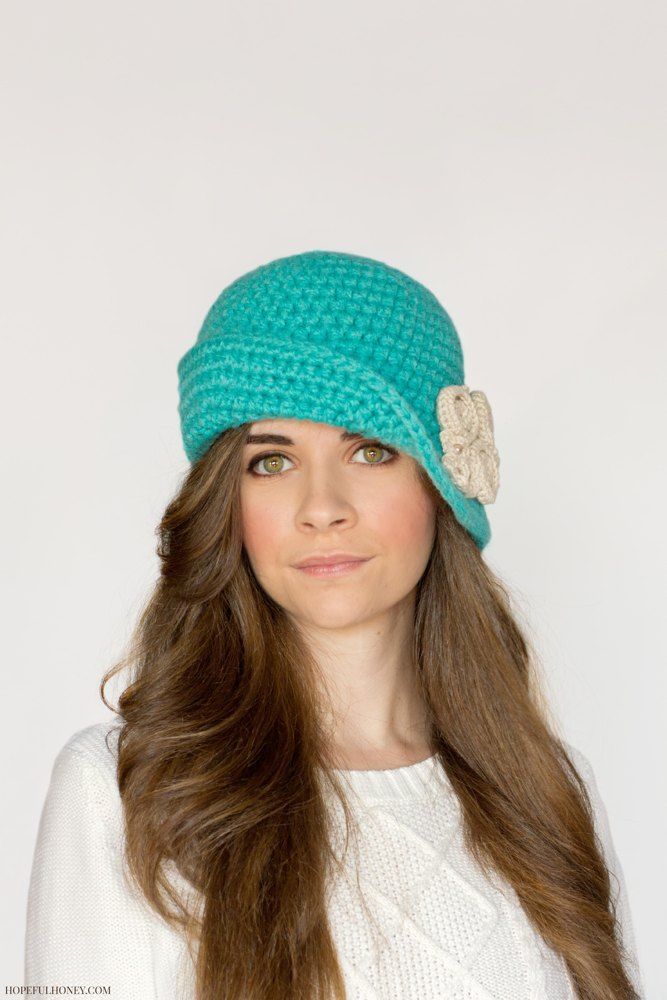 a woman with long brown hair wearing a green hat