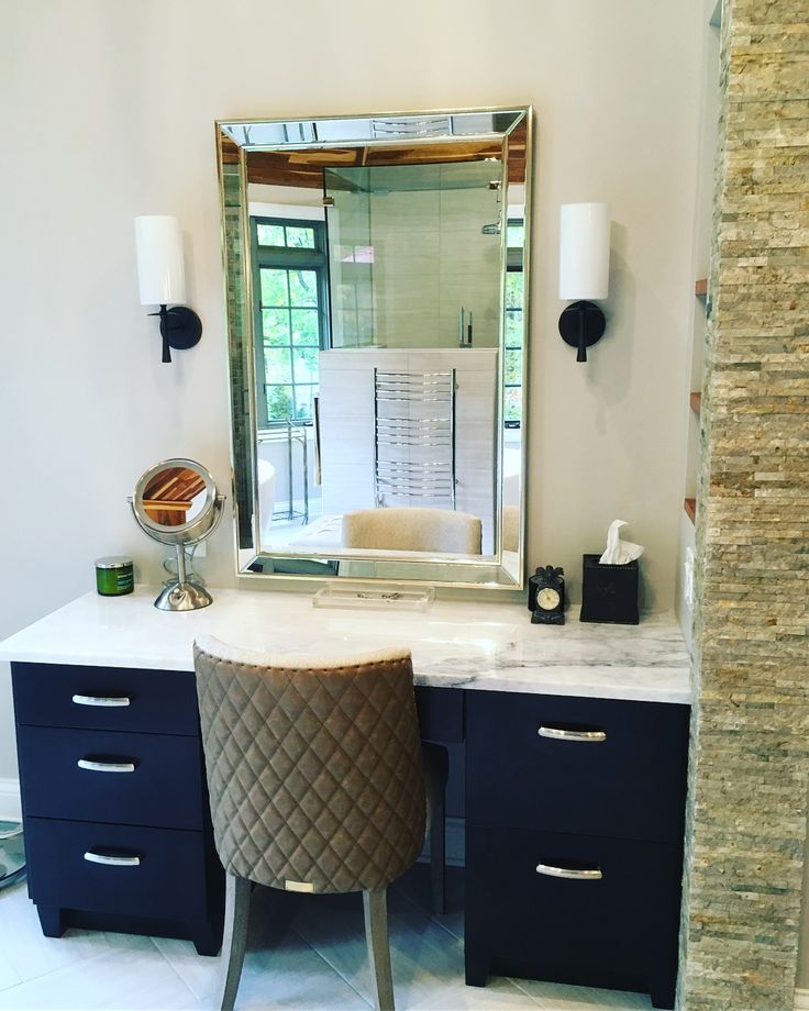 a bathroom with a vanity, mirror and stool in front of the counter top area