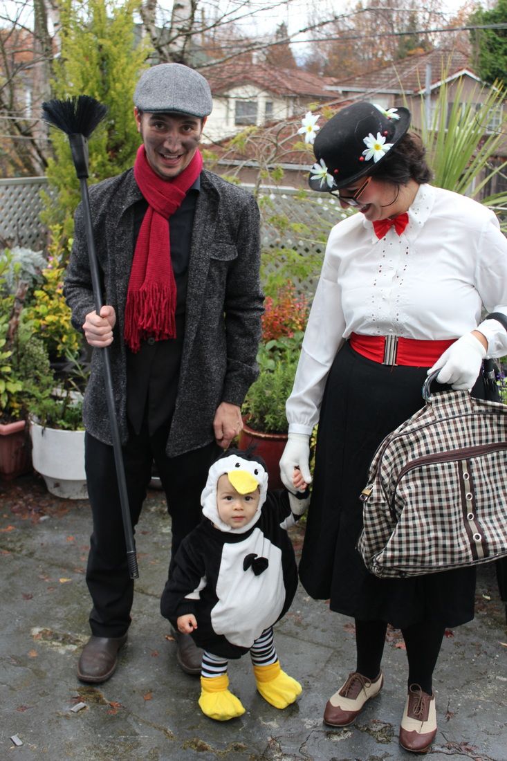 a man and woman dressed up as penguins with a baby in a penguin costume on