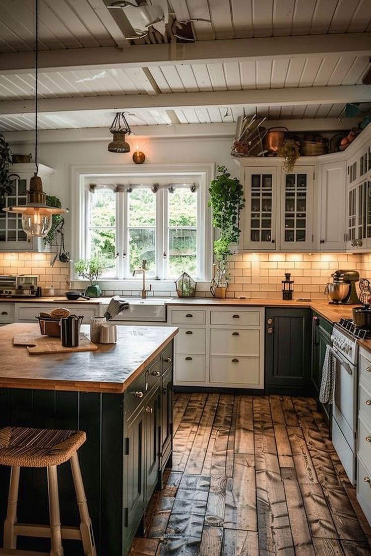 a large kitchen with wooden floors and white cabinets, an island in the middle is surrounded by potted plants