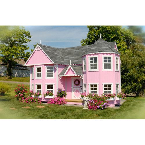 a pink doll house with flowers around it