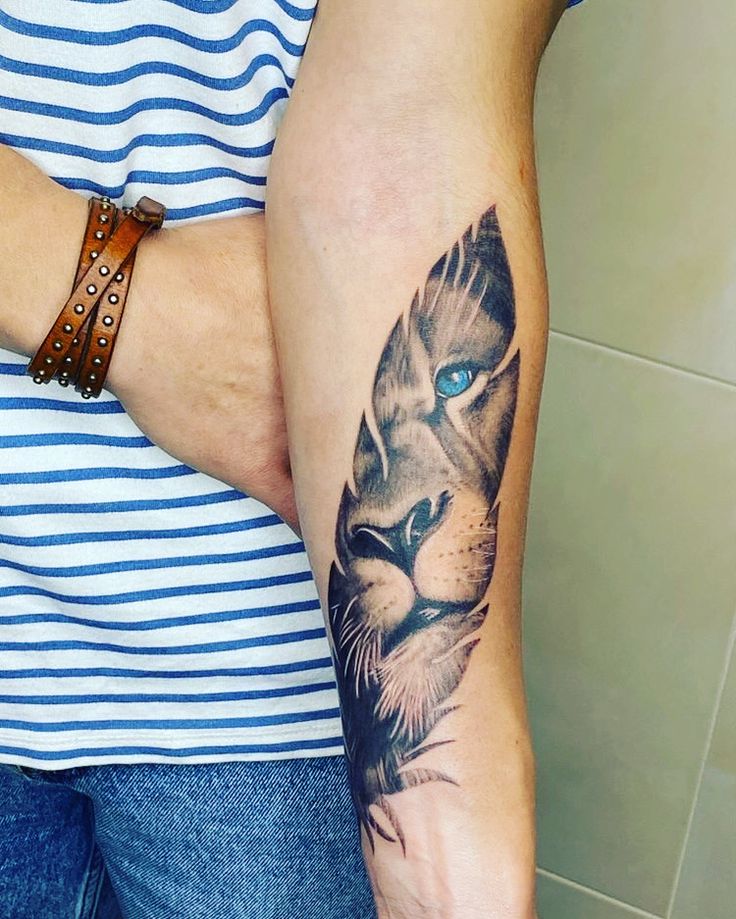 a woman's arm with a tattoo of a tiger on it and blue eyes