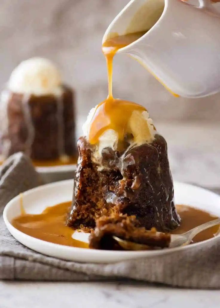 a spoon drizzling caramel sauce onto a piece of sticky toffe pudding