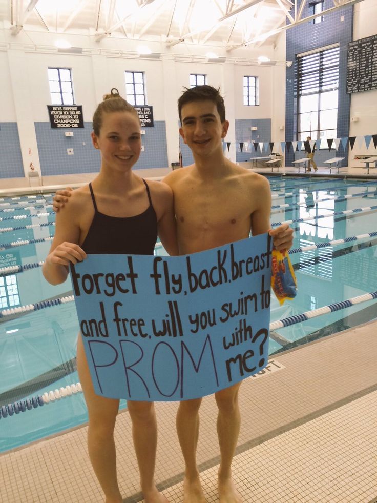 two people standing next to each other in a swimming pool holding a sign that says forget fly back across and free will you swim with me?