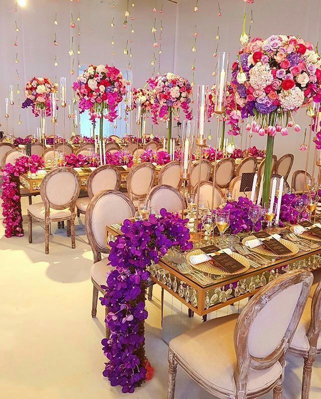 a dining room set up with flowers and candles