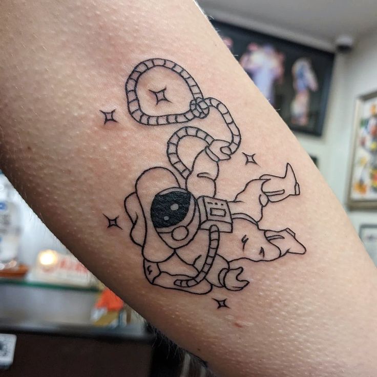 a person with a tattoo on their arm that has a dog holding a clock in it