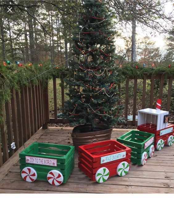 three wooden crates sitting on top of a deck next to a christmas tree with candy canes