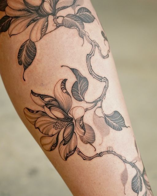 a close up of a person's leg with flowers on it