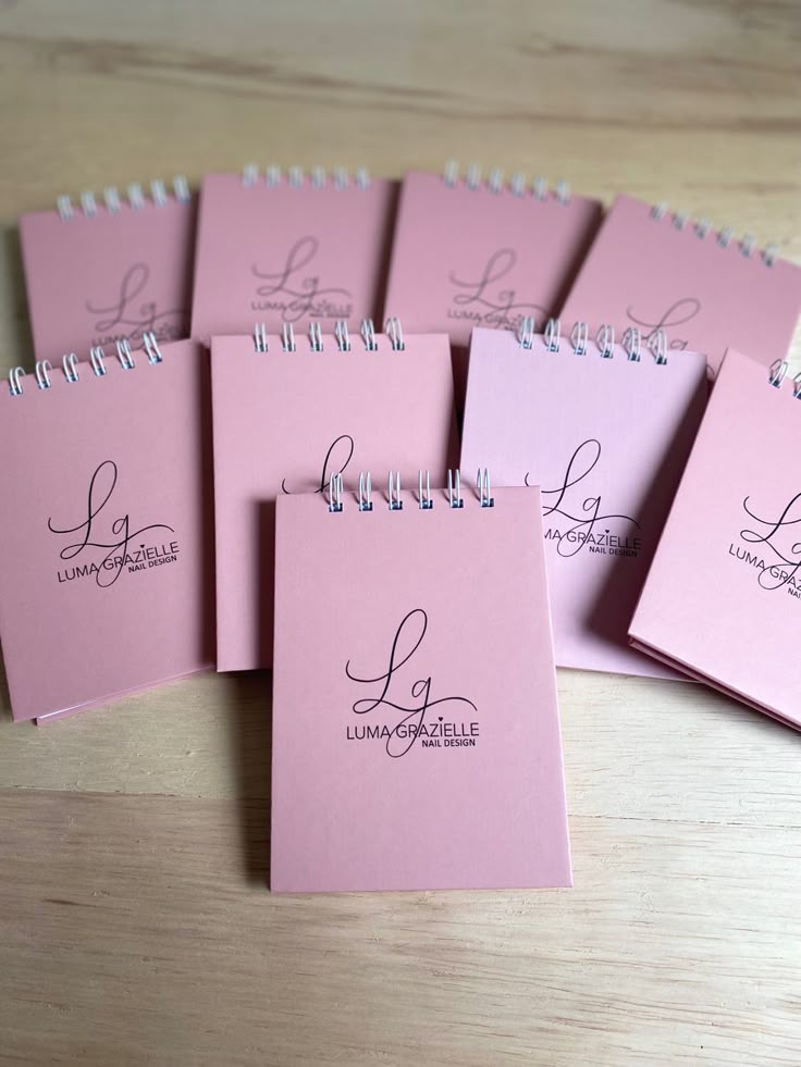 six pink notebooks with the word love written in cursive writing on them