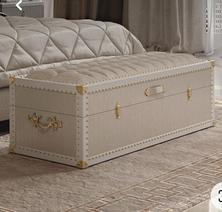 a large white trunk sitting on top of a carpeted floor next to a bed