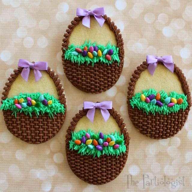 four decorated cookies with bows and eggs in the shape of easter baskets on a table