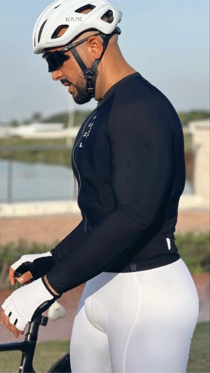 a man in white shorts and a black shirt with a bike helmet