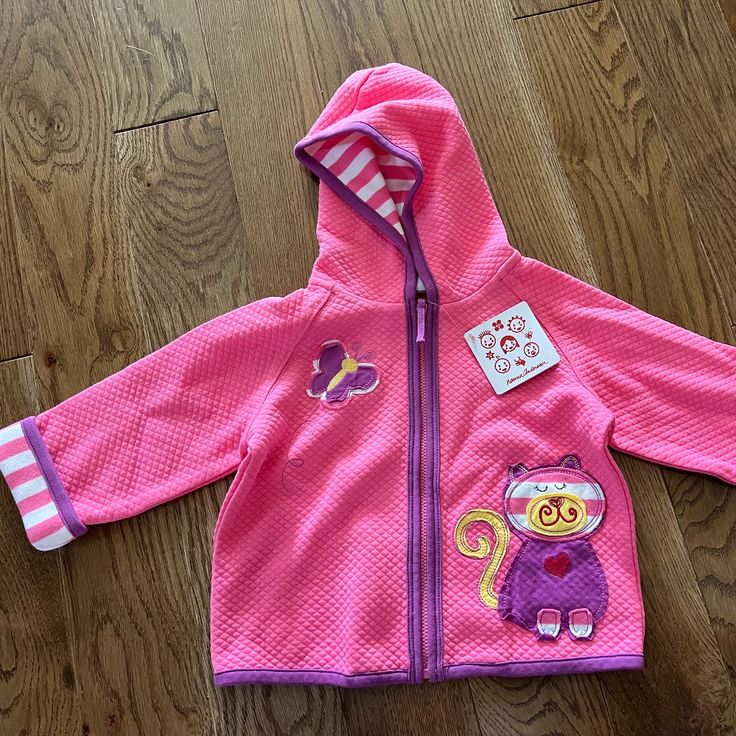 a child's pink jacket with an owl on it