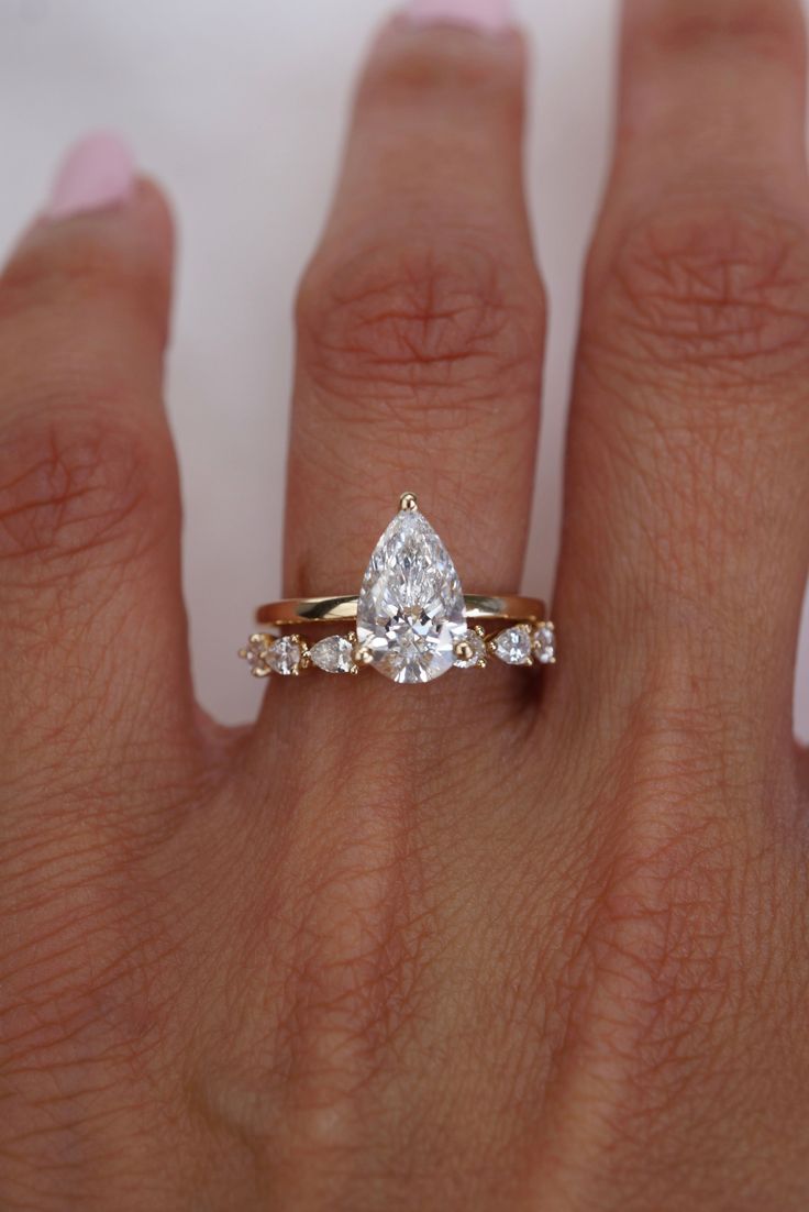 a woman's hand with a ring on it and a diamond in the middle