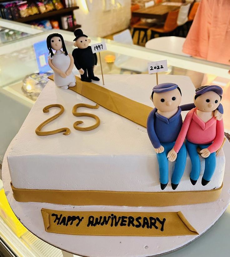 a cake with two people on it and the number twenty five in front of them