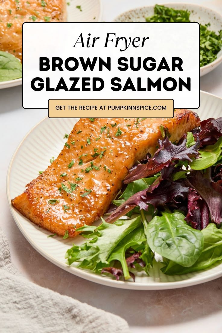 a white plate topped with salmon next to a salad and lettuce on a table