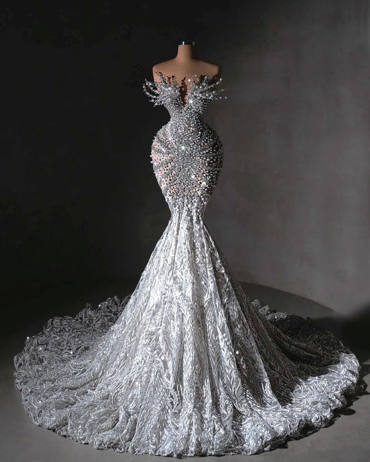 the back of a silver dress with sequins on it, in front of a black background