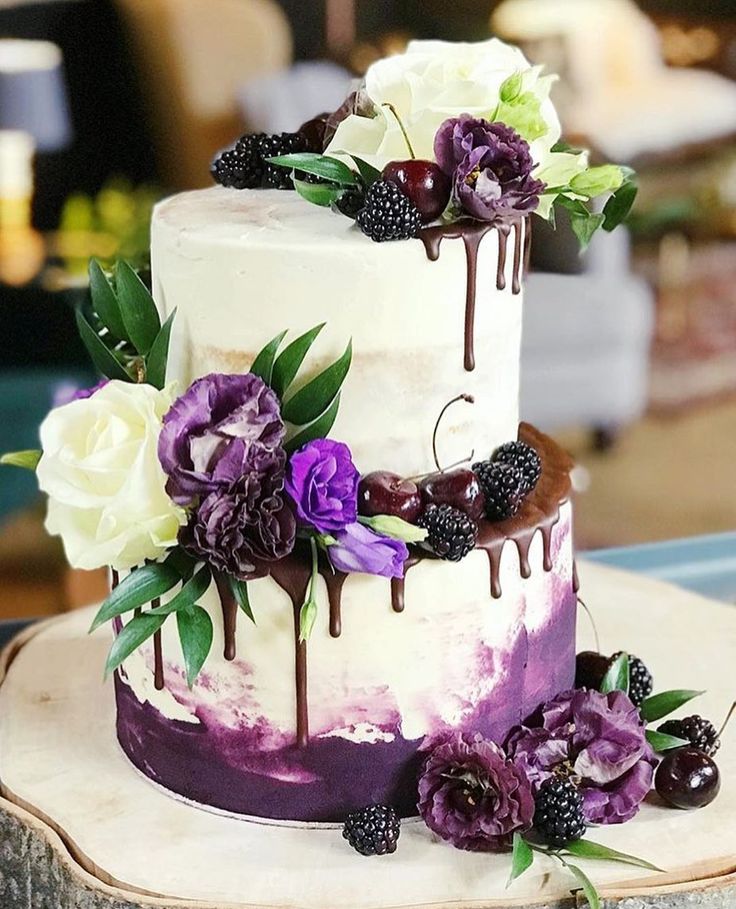 a three tiered cake with flowers and berries on top