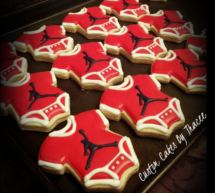 cookies decorated with red and black designs on a cookie sheet in the shape of basketball shoes