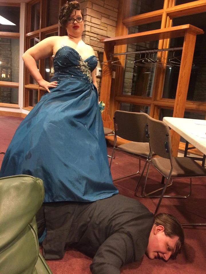 a man laying on the ground next to a woman in a blue dress