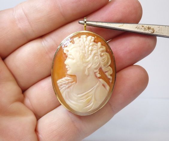 "From an estate. Marked and tested as solid 14k gold (aka 585 gold) 7.5 grams total weight Also marked Italy and a tiny makers stamp. Measures 1 5/8\" high, not including the attached bale length x 1 1/4\" width. Hand etched signature on the reverse of the cameo. Not deciphered. Real shell carved cameo, no damages.  Set and secure in yellow gold. Fully functional pin brooch and pendant. In excellent condition.  All inquiries answered. More photos possible as requested. Tracked and Insured Shipping included with the purchase. Thank you for your interest Link to my home page; https://www.etsy.com/shop/DanPickedMinerals" Oval Carved Gold Brooches, Gold Oval Carved Brooches, Collectible Carved Gold Brooches, Carved Gold Brooch For Gift, Carved Gold Brooches As Gifts, Carved Gold Brooches For Gift, Handmade Yellow Gold Brooches Collectible, Handmade Yellow Gold Brooches For Collectors, Carved Yellow Gold Brooches