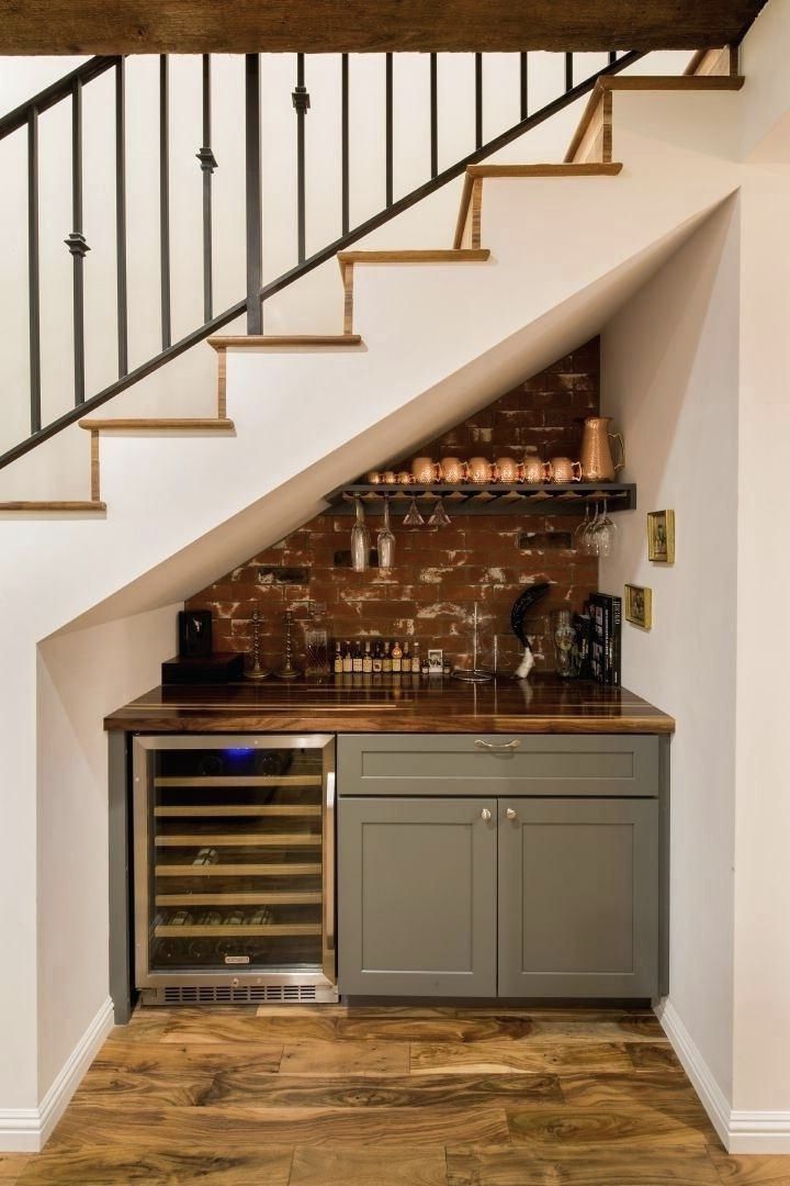 a wine rack under the stairs in a home bar with built - in wine bottles