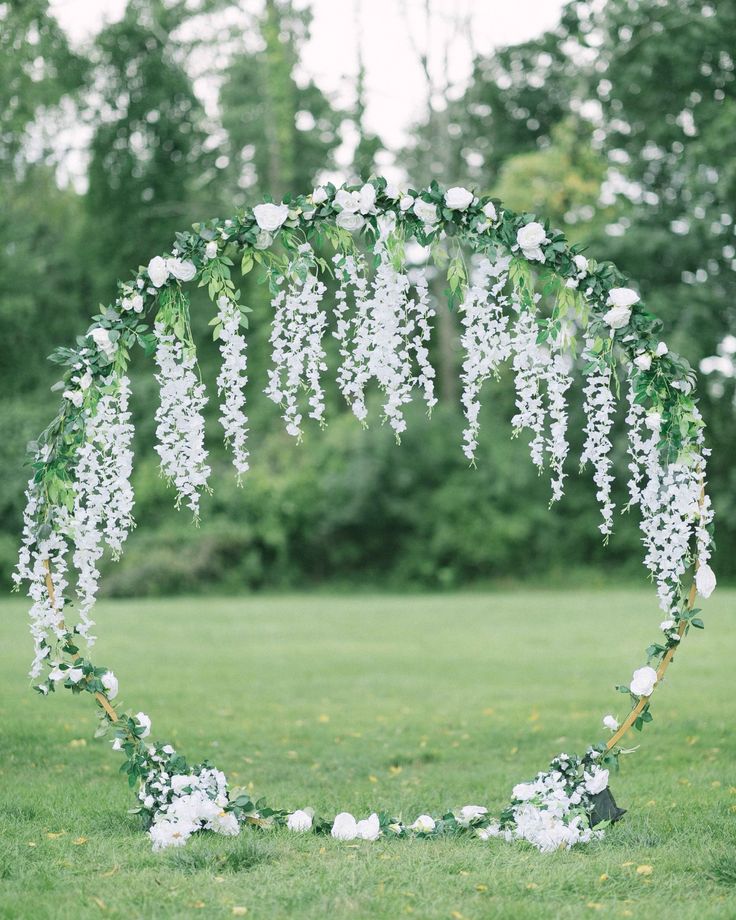 an outdoor ceremony with white flowers and greenery