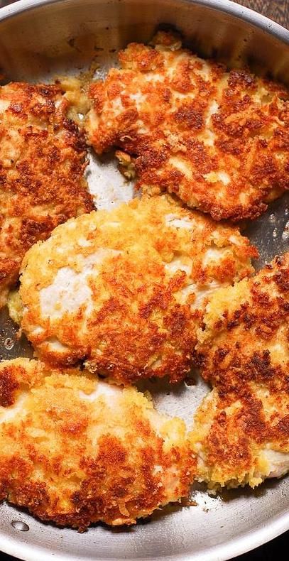 four crab cakes in a frying pan on the stove