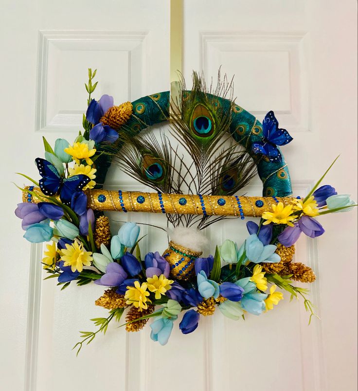 a peacock wreath with blue and yellow flowers on the front door, next to a white door