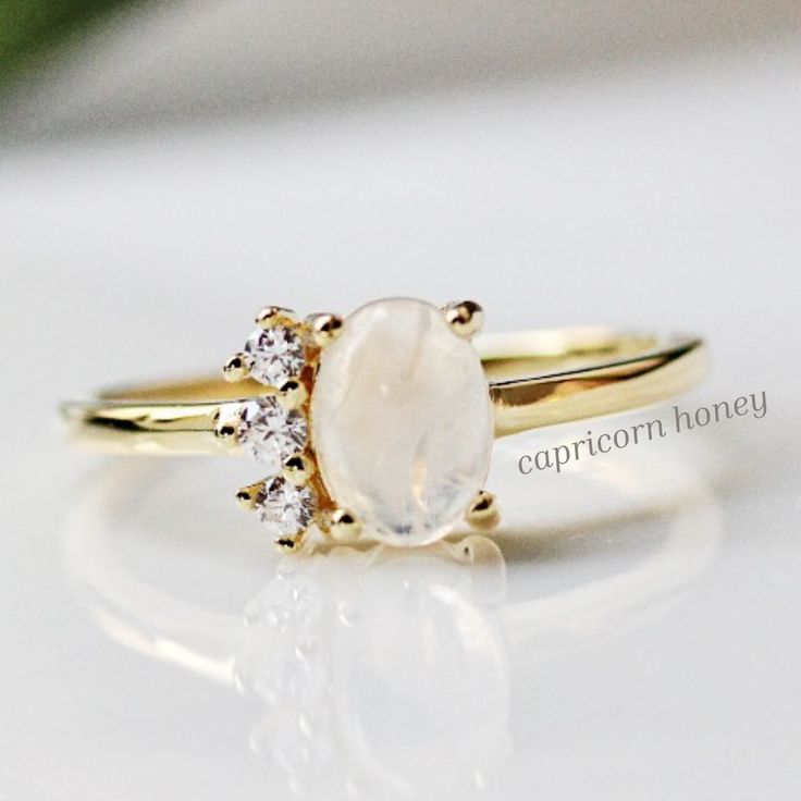 Gemstone Stacking Ring | Natural Moonstone | 14K Gold Vermeil Ring | Moonstone Engagement Ring | Promise Ring | June Birthstone | Anniversary Gift | Birthday Gift For HerChloe is a beautiful natural oval moonstone ring with three delicate CZ details on its side. This ring would be a perfect ring to stack alongside your other favorites or alone. It is petite while still alluring under any light. Limited time only. Use code MOONSTONE30 to receive 30% off. + Natural Oval Moonstone + 14K Gold Plated Dainty Oval Moonstone Promise Ring, 14k Gold Moonstone Promise Ring With Accent Stones, Wedding Moonstone Ring With Gemstone Accents In 14k Gold, Celestial Opal Birthstone Ring In Oval Shape, 14k Gold Moonstone Ring With Gemstone Accents, Gold Moonstone Ring With Gemstone Accents For Anniversary, Celestial Oval Opal Birthstone Ring, Gold Oval Moonstone Ring With Gemstone Accents, Gold Moonstone Rings With Gemstone Accents