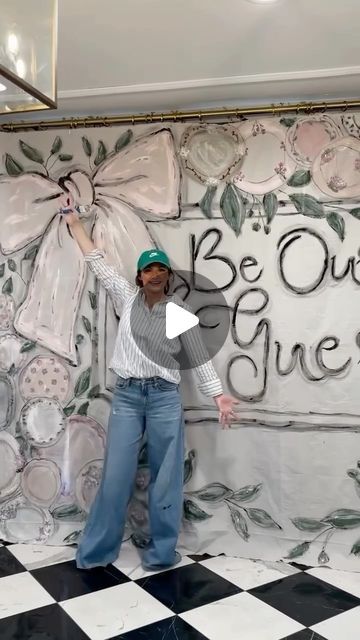 a man standing on top of a checkered floor in front of a wall painting