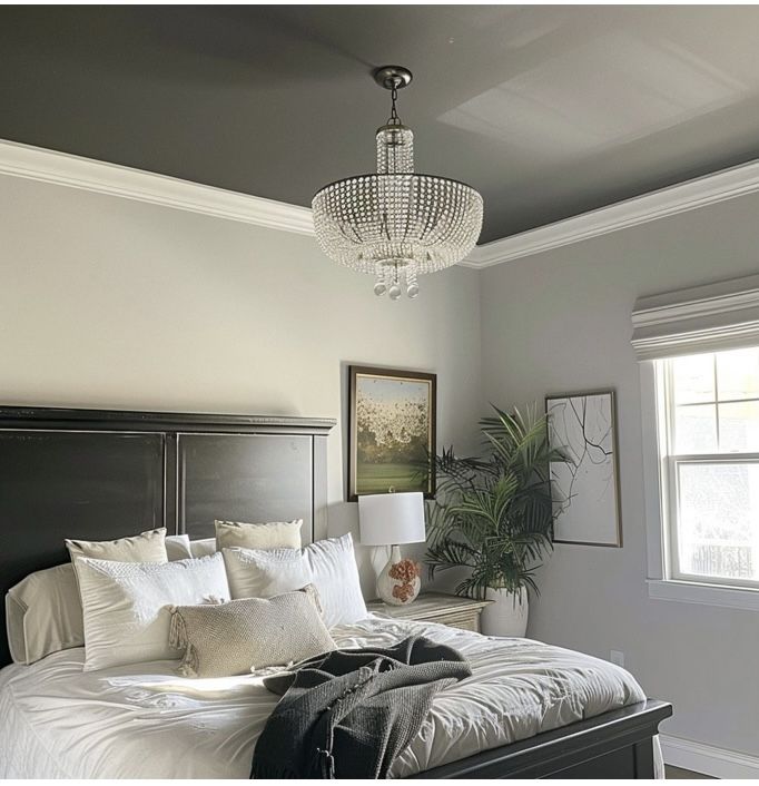 a bedroom with a chandelier hanging from the ceiling and a bed in front of it