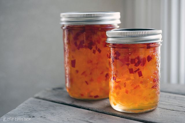 two jars filled with food sitting on top of a wooden table