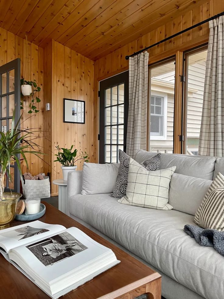 a living room filled with furniture and wooden walls