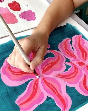 a person is using a pencil to paint flowers on paper with acrylic colors