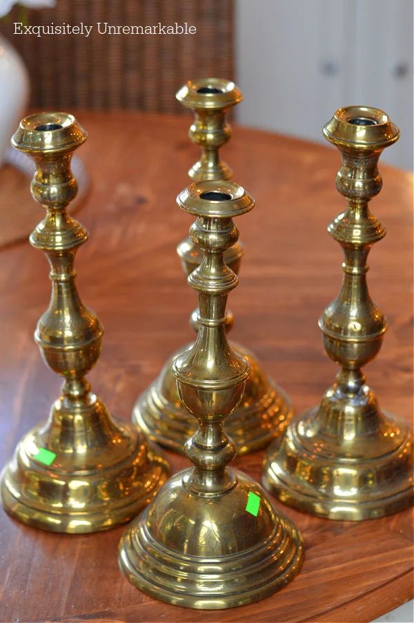 three brass candlesticks sitting on top of a wooden table