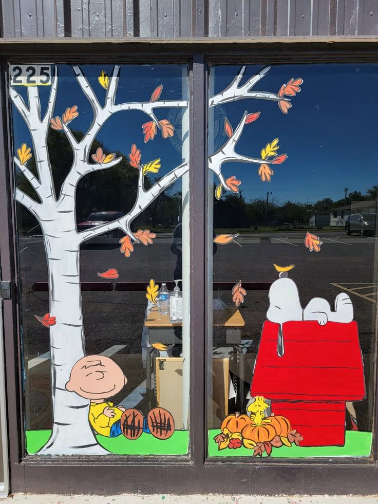 there is a window decorated with the characters of charlie brown and snoopy on it