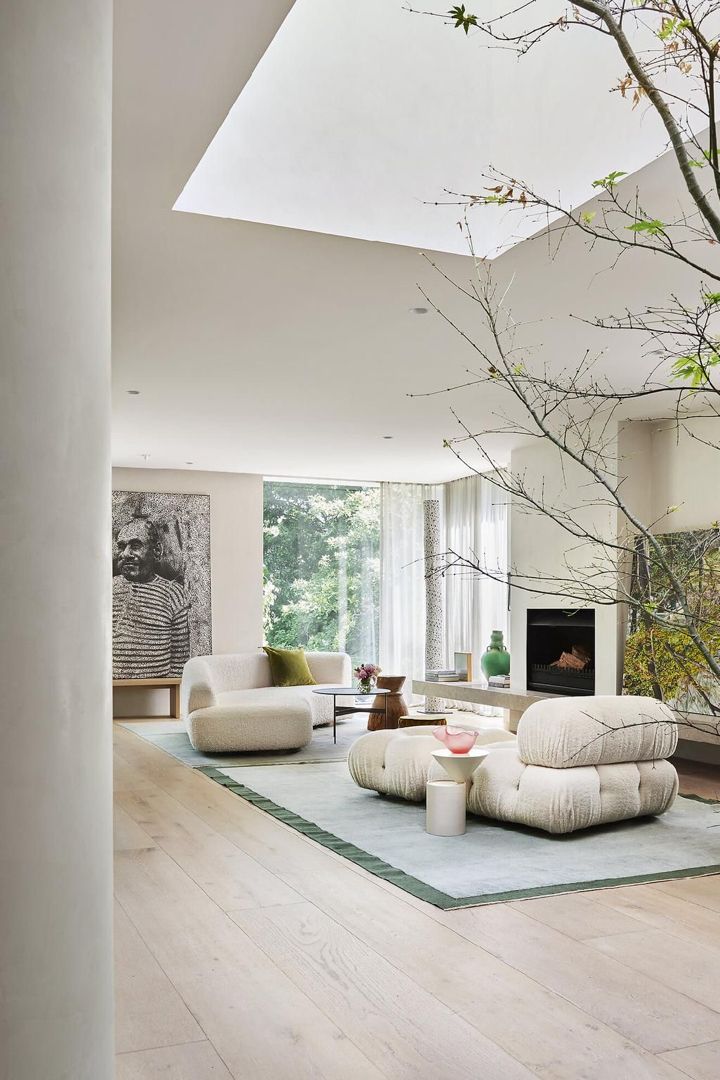 a living room filled with furniture and a tree in the middle of it's floor